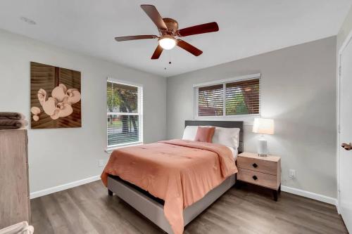 a bedroom with a bed and a ceiling fan at Serene Deck 10 Mins Garland City Square in Garland