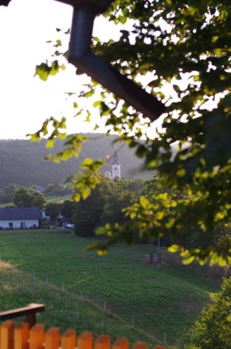a view of a field with a lighthouse in the distance at Hiška na skalci, The House on the Rock in Krka