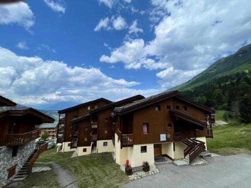 un groupe de bâtiments avec des montagnes en arrière-plan dans l'établissement Résidence Lauziere Dessus G - LAUZIERE DESSUS 8 MAE-7101, à Valmorel