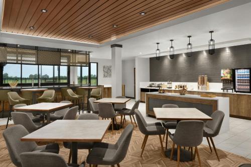 een restaurant met tafels en stoelen en een keuken bij TownePlace Suites by Marriott Sikeston in Sikeston
