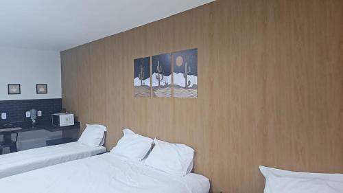 a hotel room with two beds and a desk at Nobre Flats 201 in Petrolina