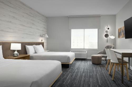 a hotel room with two beds and a table at TownePlace Suites by Marriott Sikeston in Sikeston