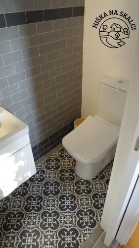 a bathroom with a toilet and a tile floor at Hiška na skalci, The House on the Rock in Krka
