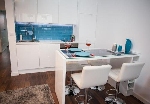 a kitchen with a counter with two glasses of wine at Apartament Nad Morzem in Darłówko