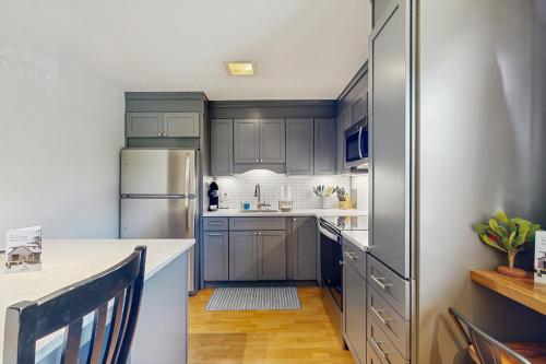 a kitchen with gray cabinets and a refrigerator at Topside Garden in North Conway