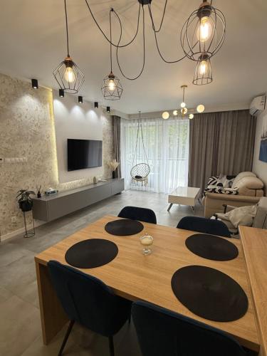 a living room with a dining table and a living room at Klifowa Apartament Premium in Rewal