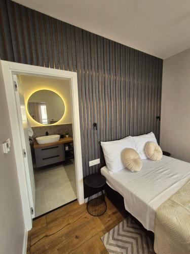 a bedroom with a bed with a mirror and a sink at Villa Restart Vrsi-Mulo in Vrsi