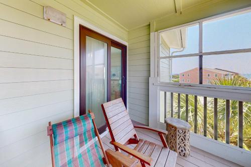 a rocking chair on a porch with a window at Suite Retreat in Emerald Isle
