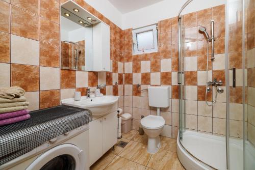 ein Badezimmer mit Waschbecken, Toilette und Dusche in der Unterkunft Apartments Toni in Banjol