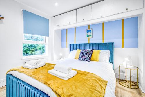 a bedroom with a blue and yellow striped wall at Wimbledon 3Bath Sleeps7 AELTC in London