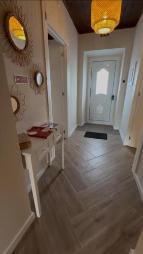 a hallway with a table and a door with a mirror at Brisa do Nordeste in Nordestinho