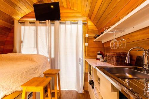 eine Küche mit einem Bett und einem Waschbecken in einem Zimmer in der Unterkunft Cabana com banheira em formato de barril in Curitiba