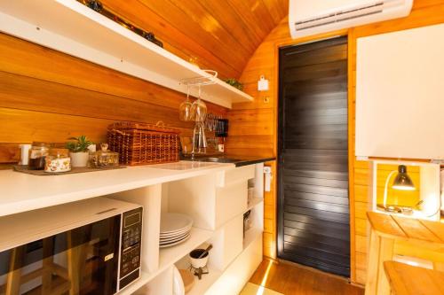 eine Küche mit Holzwänden und einer schwarzen Tür in der Unterkunft Cabana com banheira em formato de barril in Curitiba
