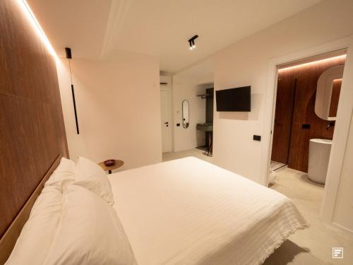 a bedroom with a white bed and a bathroom at Cefalù Luxury Suite in Cefalù
