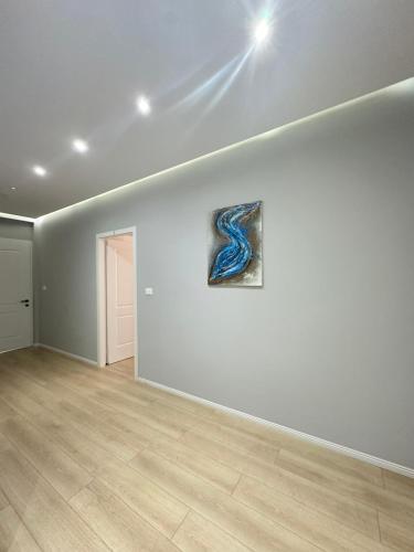a white room with a painting on a wall at Saranda Apartments in Sarandë