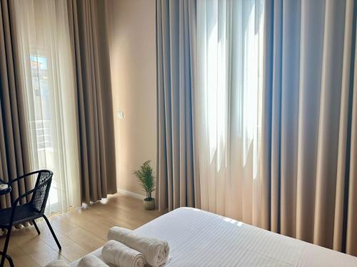 a bedroom with a bed and a window with curtains at Saranda Apartments in Sarandë