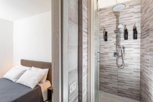 una doccia con porta in vetro accanto a un letto di Matrangela B&B Catania a Catania