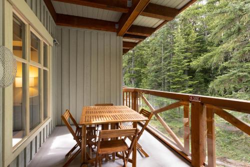 a porch with a wooden table and chairs on it at Horstman House by Whistler Premier in Whistler
