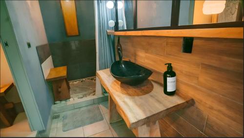 a bathroom with a bowl and a bottle of wine at Ikiru Villa in Cóbano