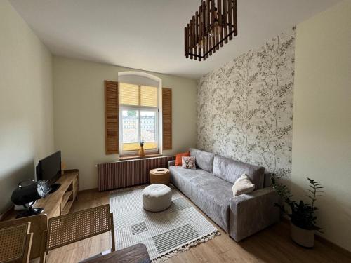 a living room with a couch and a tv at Apartament Zielona Kamienica in Koszalin