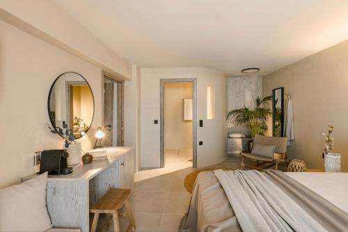 a bedroom with a large bed and a mirror at Cássia Suite in Kefalonia with Balcony Nomāde Agora in Lixouri