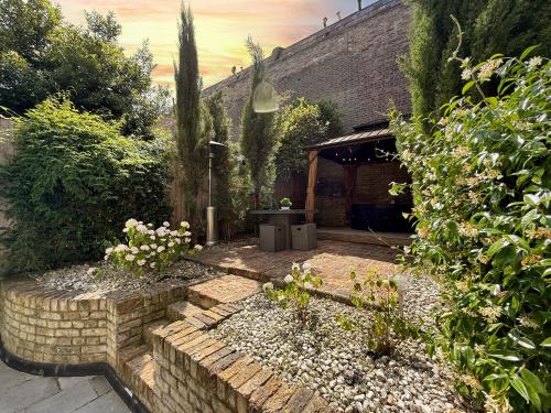 a garden with a stone walkway and a building at London Queen's Park with cinema & gaming room in London
