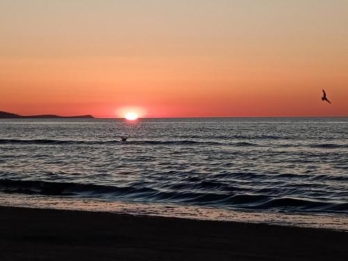 a person riding a surfboard in the ocean at sunset at APART PARK -Lividus112 in Świnoujście