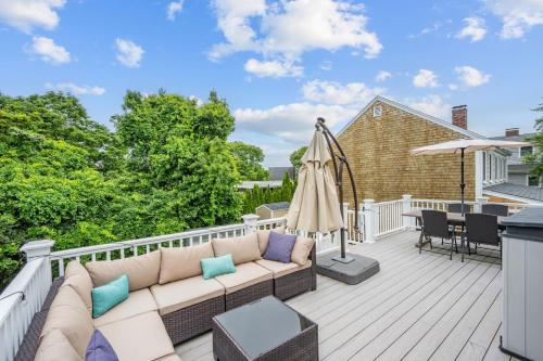 a patio with a couch and an umbrella on a deck at 7 Bodfish Avenue Sandwich - Life's A Beach! in Sandwich