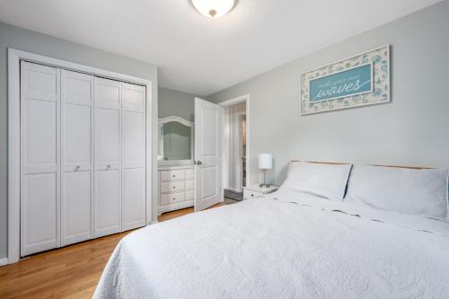 a white bedroom with a bed and a closet at 7 Bodfish Avenue Sandwich - Life's A Beach! in Sandwich