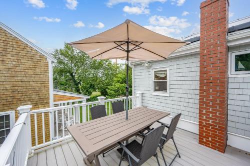 a wooden table with an umbrella on a deck at 7 Bodfish Avenue Sandwich - Life's A Beach! in Sandwich