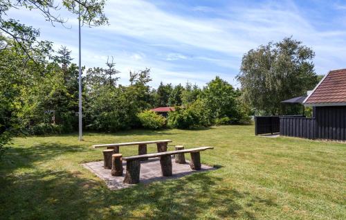 a wooden bench sitting in the grass in a park at Amazing Home In Skjern With Wifi in Skjern