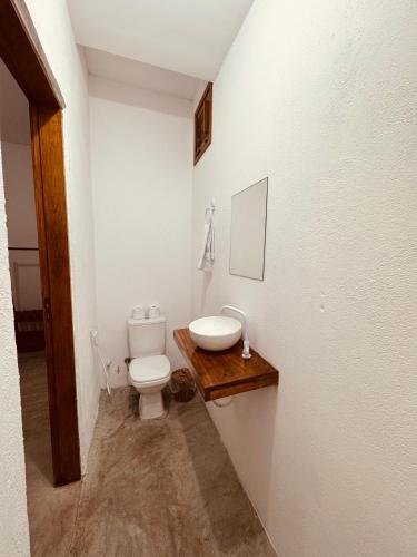 a bathroom with a toilet and a sink at Lu Pousada Charme Preá in Prea