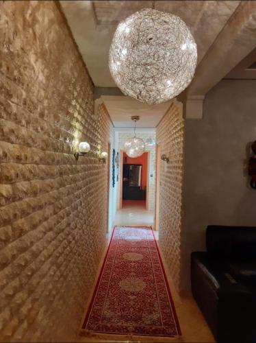 a hallway with a brick wall and a chandelier at Beach apartment Agadir in Agadir