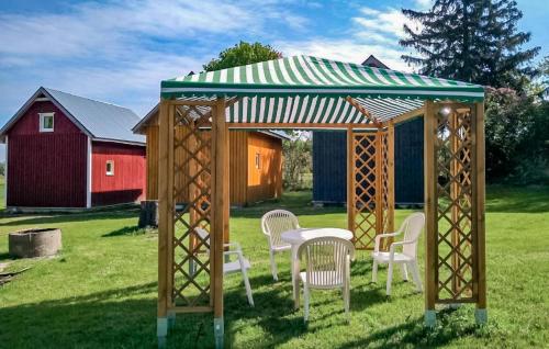Un cenador con sillas y una mesa en un campo en 2 Bedroom Nice Home In Ilawa, en Iława