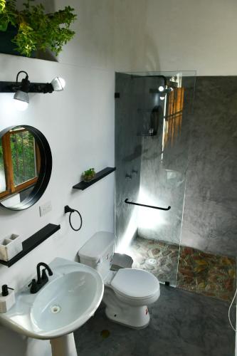 a bathroom with a toilet and a sink and a shower at Posada Casa del Sol in Caracas