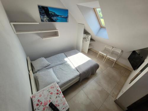 a small white bedroom with a bed and a window at Bartpol Family & SPA in Gródek Nad Dunajcem