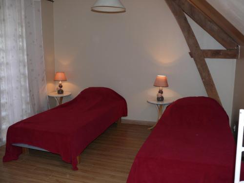 two beds in a room with two lamps on two tables at Ferme renel in Poses