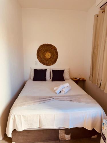 a bedroom with a large white bed with two pillows at Lu Pousada Charme Preá in Prea