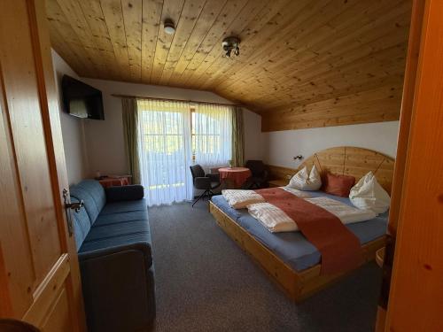 a bedroom with a bed and a couch in a room at Sauschneid Hof in Taxenbach