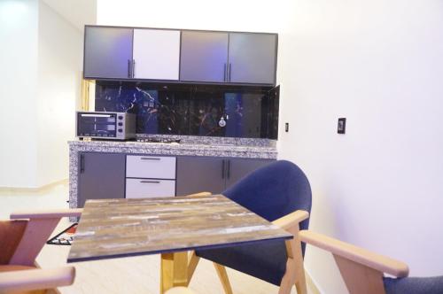 a kitchen with a wooden table and two chairs at 2 Voies Résidence in Dakhla