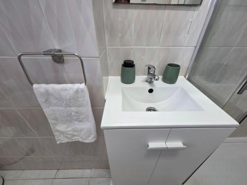 a bathroom with a sink with two green cups on it at Peaceful Stay - Lisbon in Amadora