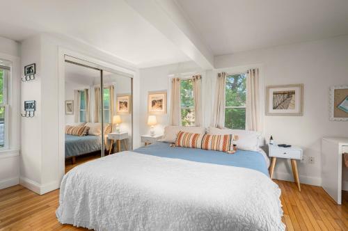 a bedroom with a large bed and two windows at Babes Bungalow by Leavetown Vacations in Orleans