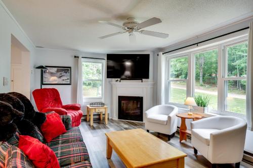 a living room with a red couch and a fireplace at Outdoor Exploration Quaint North Conway Cottage! in North Conway