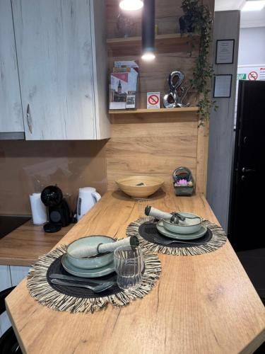 a kitchen counter with plates and utensils on a table at Maslačak Subotica in Subotica