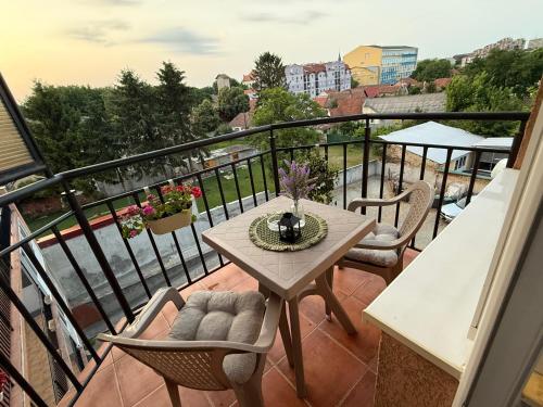 a balcony with a table and chairs on it at Maslačak Subotica in Subotica