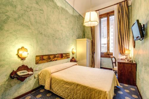 a hotel room with a bed and a television at Hotel Croce Di Malta in Florence