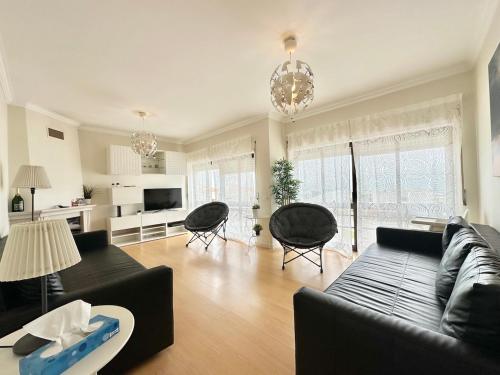 a living room with a black couch and chairs at Deluxe Oceanfront - Vue Sur la Mer in Peniche