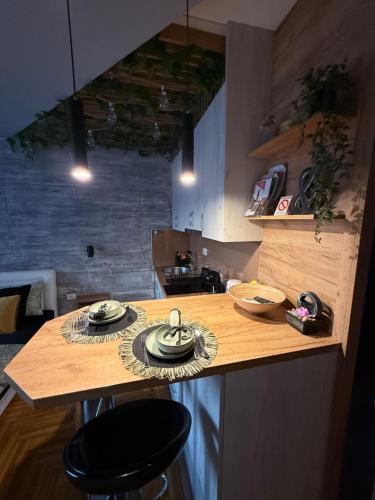 a kitchen with a counter with plates and dishes on it at Maslačak Subotica in Subotica