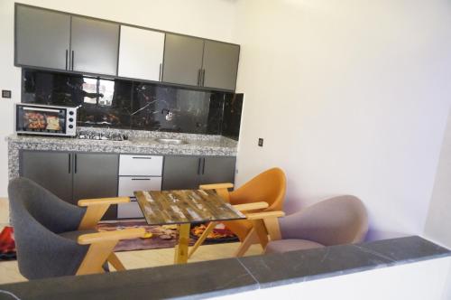 a kitchen with a table and chairs and a counter at 2 Voies Résidence in Dakhla