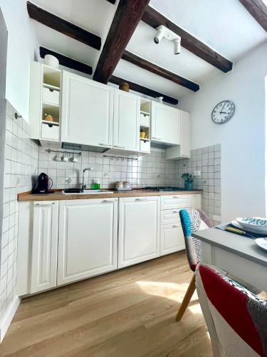 a kitchen with white cabinets and a clock on the wall at Casa Pierina in Vicchio